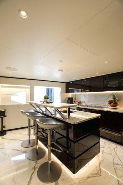 Luxurious 2025 Majesty 120 yacht interior with modern kitchen and sleek marble flooring.