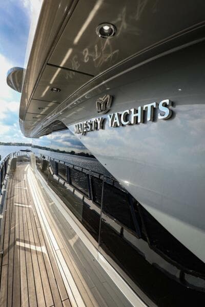 Majesty 120 yacht, 2025 model, sleek design with wooden deck and reflective hull.