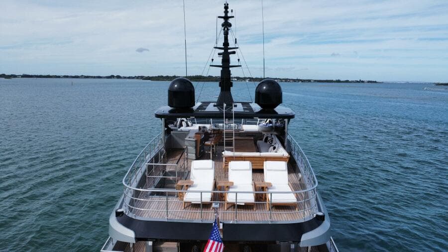 Majesty 120 yacht, 2025 model, cruising on open water with deck chairs and American flag.