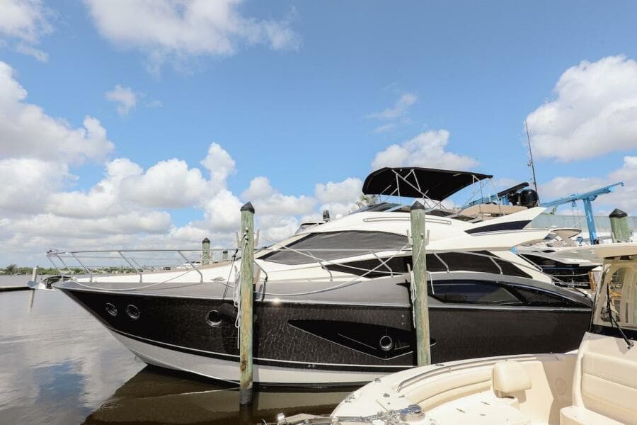 2017 Marquis 500 Sport Yacht docked at marina under blue sky.