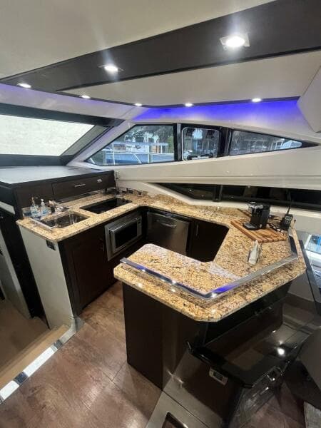 Luxurious kitchen area in a 2017 Marquis 500 Sport Yacht with granite countertops.