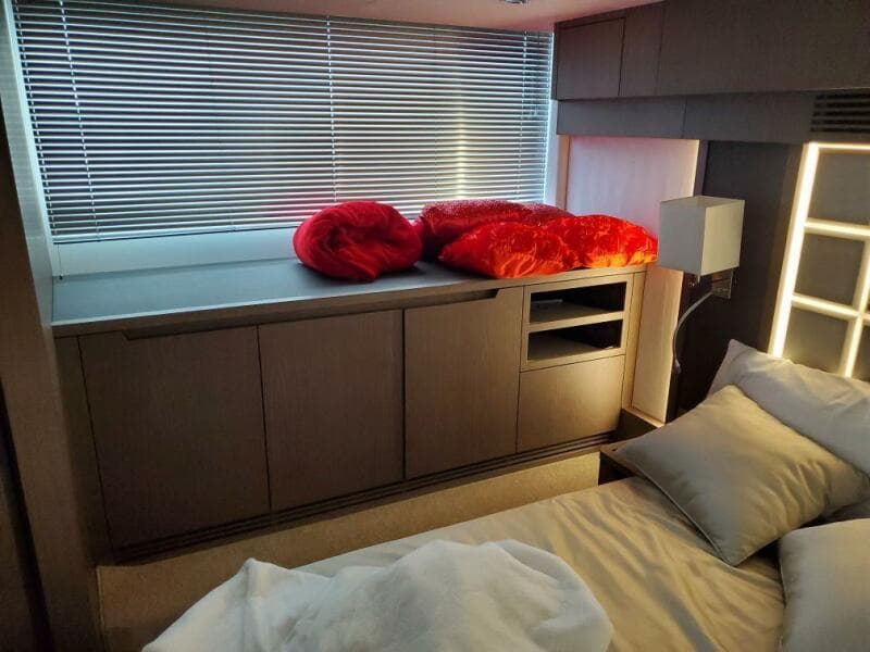 Modern bedroom interior of 2020 Galeon 500 Fly yacht with sleek cabinetry and window blinds.