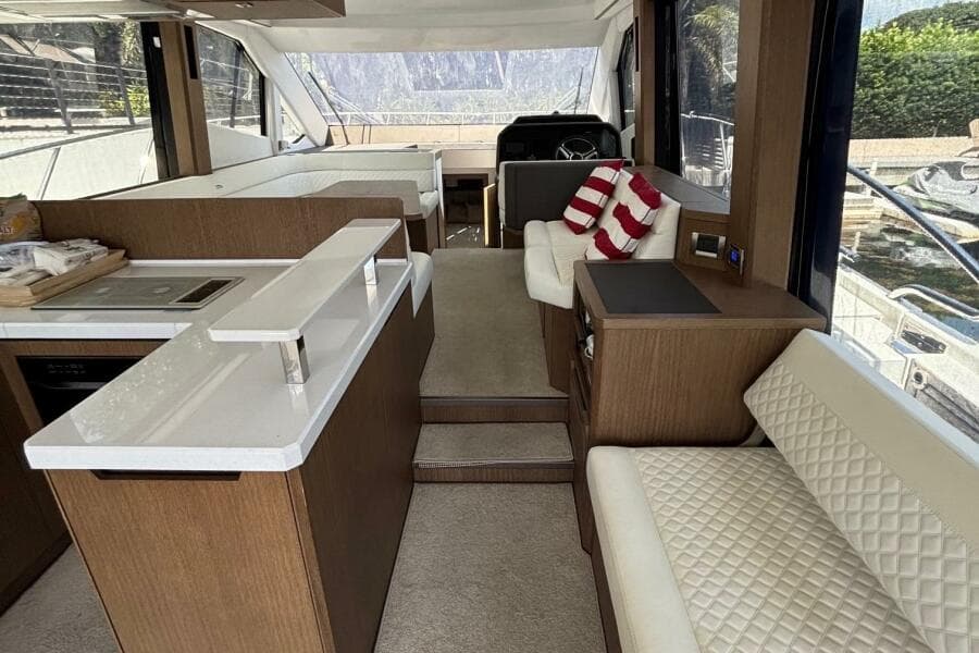 Luxurious interior of 2020 Galeon 500 Fly yacht with modern seating and kitchen area.