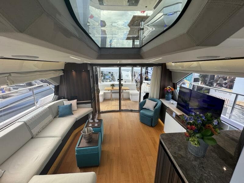 Luxurious interior of 2024 Aicon 66 Vivere yacht with modern furnishings and panoramic windows.