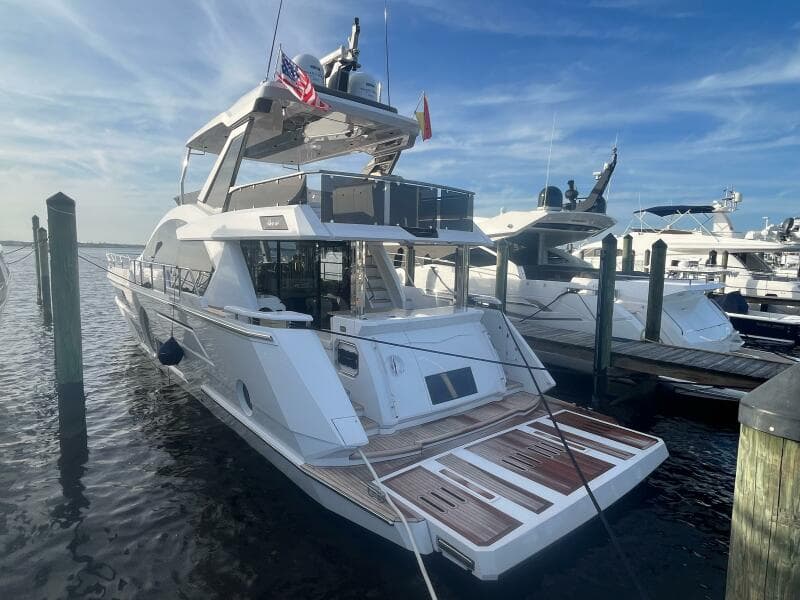 2024 Aicon 66 Vivere yacht docked at marina under clear blue sky.