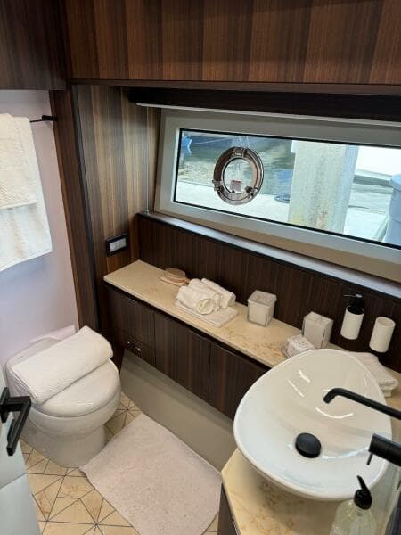 Luxurious bathroom in 2024 Aicon 66 Vivere yacht with modern fixtures and elegant wood finishes.