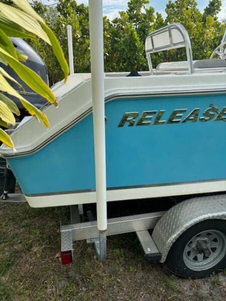 2016 Release 208 RX boat on trailer, blue and white design, parked outdoors.