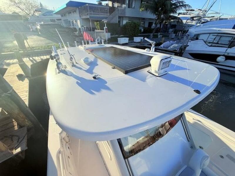 2014 Everglades 355 Center Console boat docked, featuring a sleek white design and modern equipment.