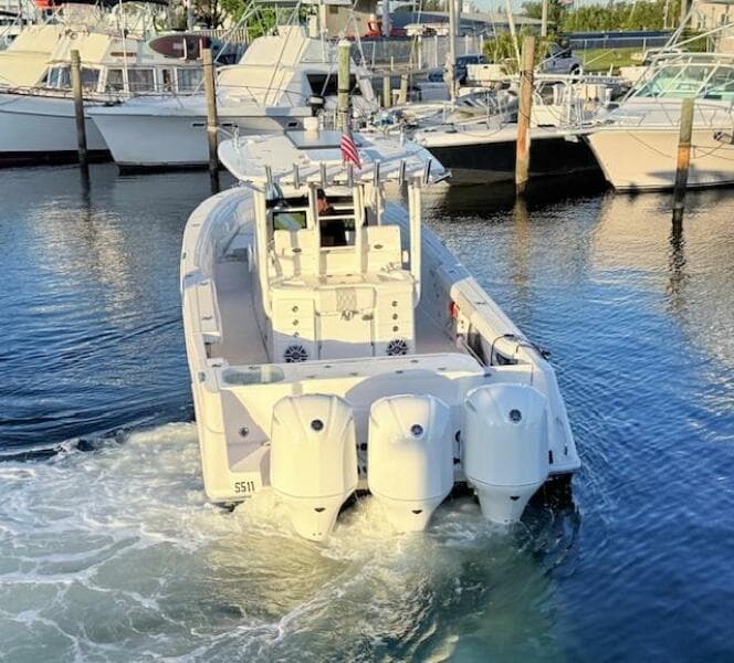 2014 Everglades 355 Center Console boat with triple engines in a marina.