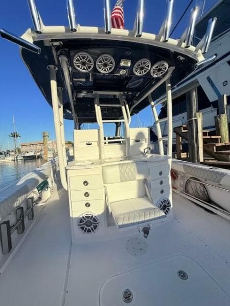 2014 Everglades 355 Center Console boat with seating and speakers, docked at a marina.