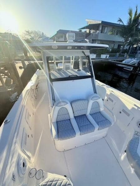 2014 Everglades 355 Center Console boat docked in sunny marina.