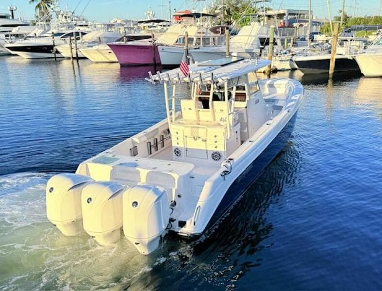 2014 Everglades 355 Center Console boat with triple engines in a marina setting.