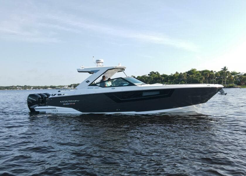 2023 Monterey 385 Super Sport boat cruising on a calm lake.