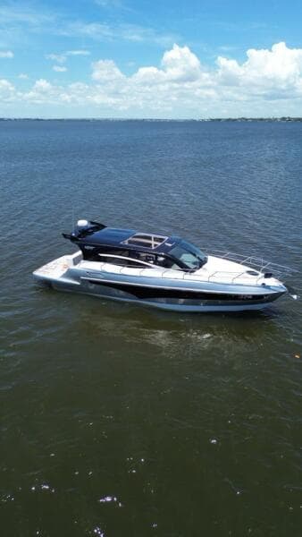 Luxury yacht "Real 40 HT" on open water, 2025 model, under clear blue sky.