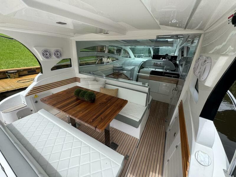 2025 Real 40 HT Luxury yacht interior with elegant seating and wooden table.