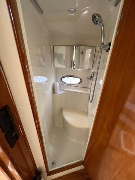 Compact shower in 2000 Carver 396 Motor Yacht with oval window and modern fixtures.