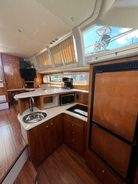 Interior of 2000 Carver 396 Motor Yacht with modern kitchen and wood finishes.
