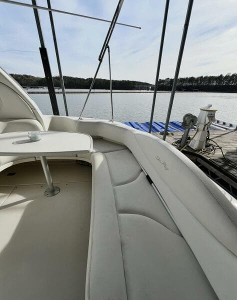 2001 Sea Ray 380 Sundancer boat interior with seating and table, docked by a serene lake.