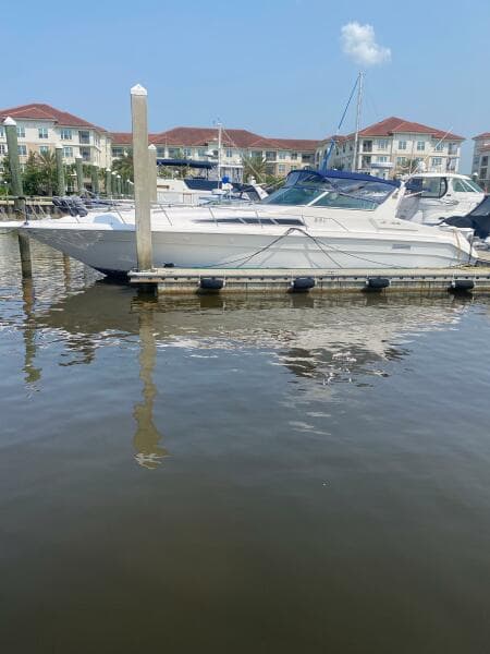 1993 Sea Ray 440 Sundancer yacht docked at marina, calm water, sunny day.
