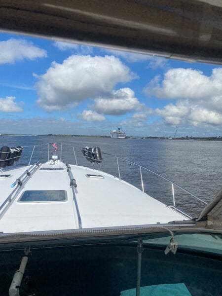 1993 Sea Ray 440 Sundancer cruising on a sunny day with blue skies and clouds.
