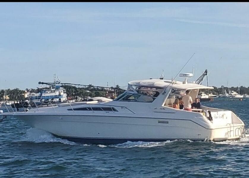 1993 Sea Ray 440 Sundancer yacht cruising on a sunny day with passengers onboard.