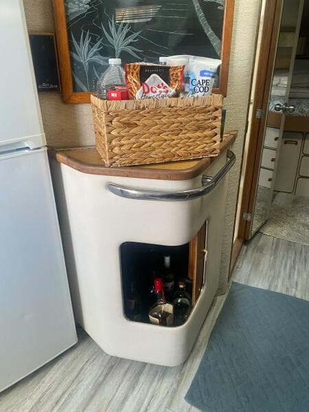 Interior of 1993 Sea Ray 440 Sundancer with a small bar area and wicker basket.