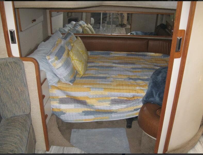 Cozy cabin interior of 1993 Sea Ray 440 Sundancer with patterned bedding.