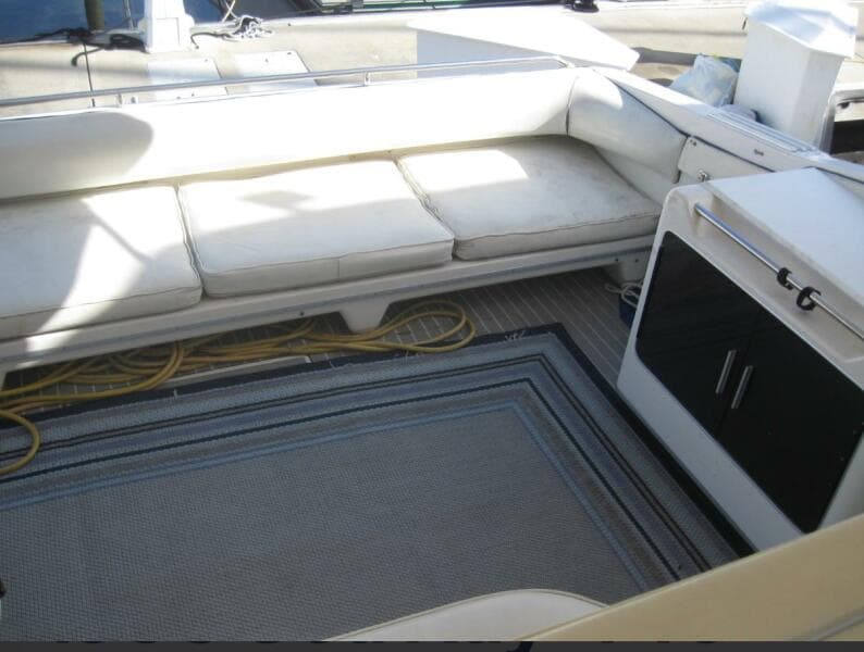Interior seating area of a 1993 Sea Ray 440 Sundancer yacht with cushions and storage.