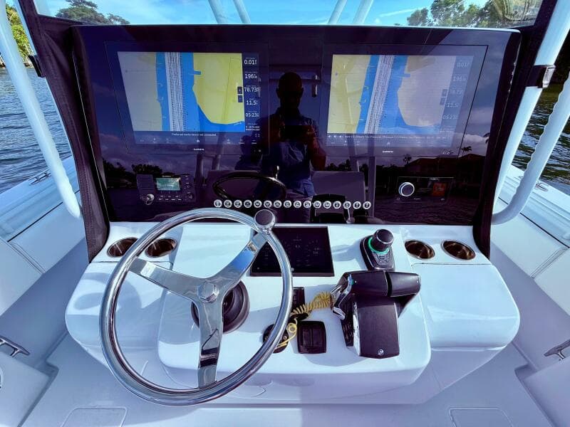 2024 Contender 39 ST boat dashboard with dual navigation screens and steering wheel.