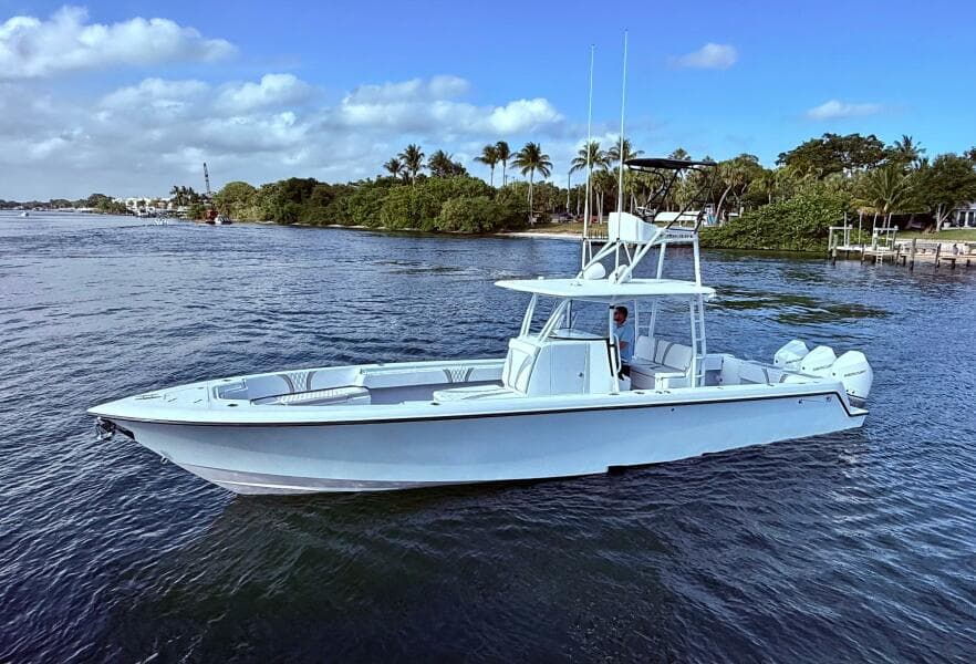2024 Contender 39 ST boat on calm water with scenic background.