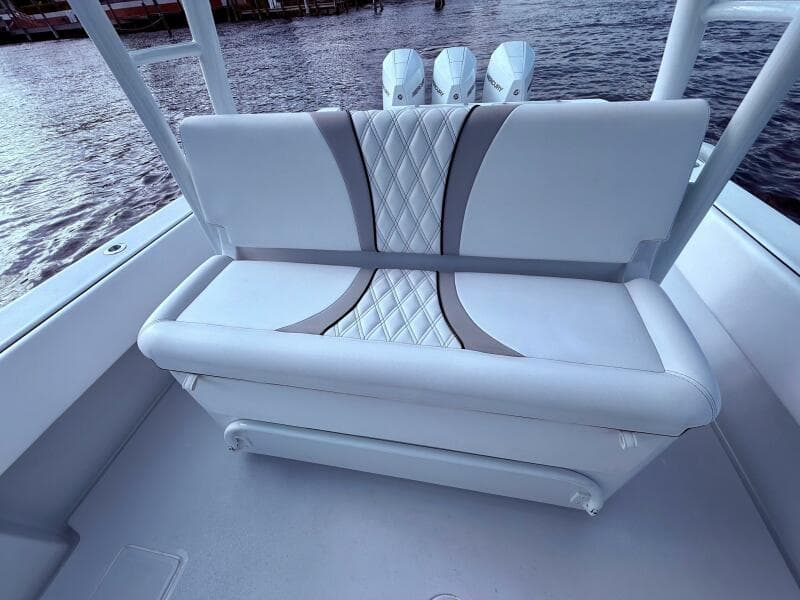 2024 Contender 39 ST boat with stylish cushioned seating and triple outboard motors.