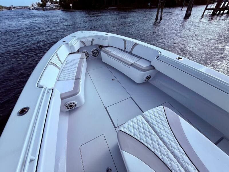 2024 Contender 39 ST boat interior with cushioned seating and speakers on calm water.