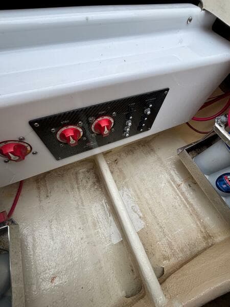Control panel of 2013 Statement 35 Center Console boat with red switches and wiring.