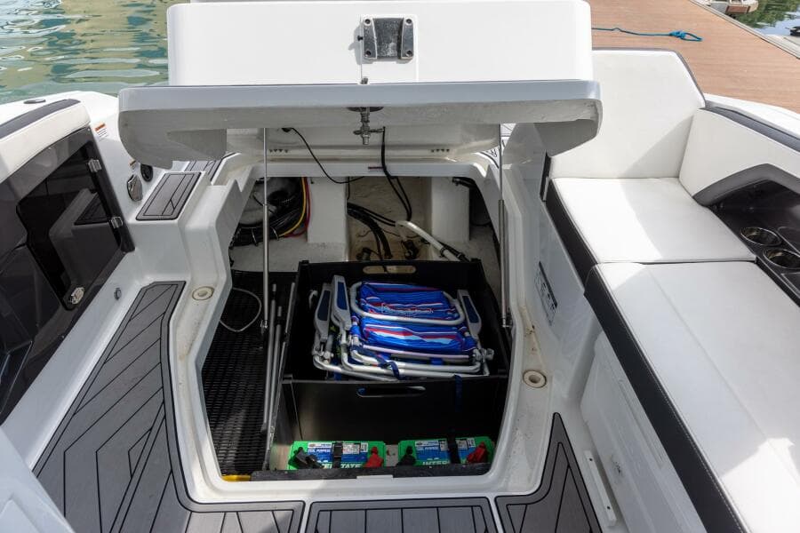 2023 Monterey 255 Super Sport boat storage compartment with beach chairs and supplies.