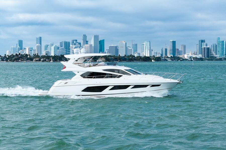 2016 Sunseeker Manhattan 65 yacht cruising with city skyline backdrop.