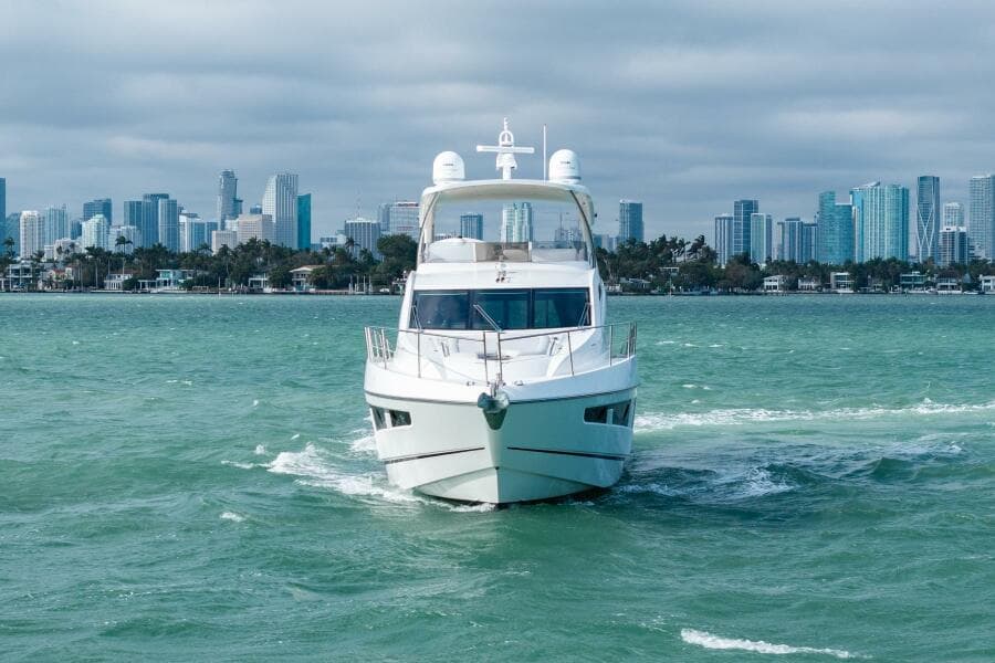 2016 Sunseeker Manhattan 65 yacht cruising with city skyline in the background.