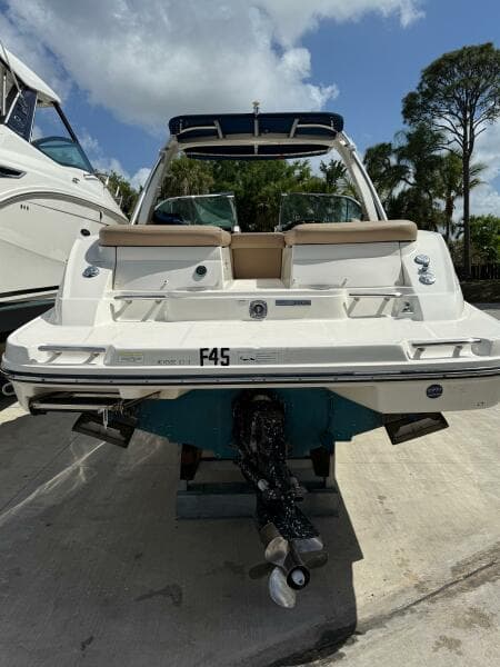 2014 Sea Ray 270 SLX boat, rear view, docked under a cloudy sky.