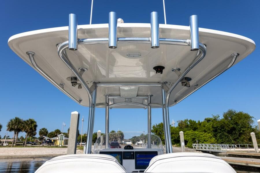 2018 Jupiter 26 FS boat with T-top and rod holders, docked under clear blue sky.