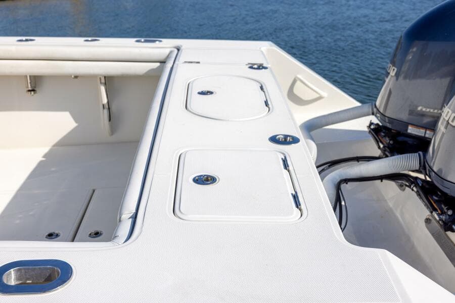 2018 Jupiter 26 FS boat deck with storage compartments and dual engines.