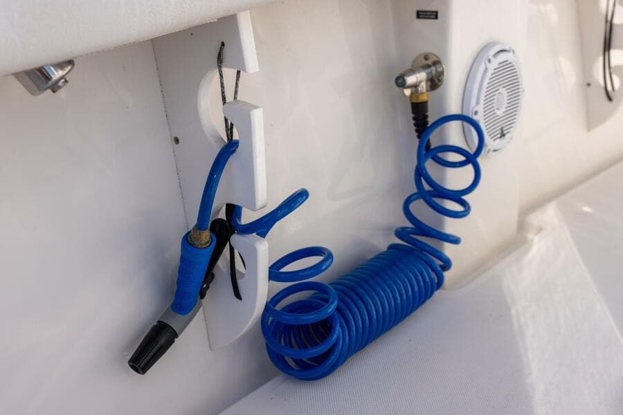 Blue coiled hose and nozzle on 2018 Jupiter 26 FS boat deck.