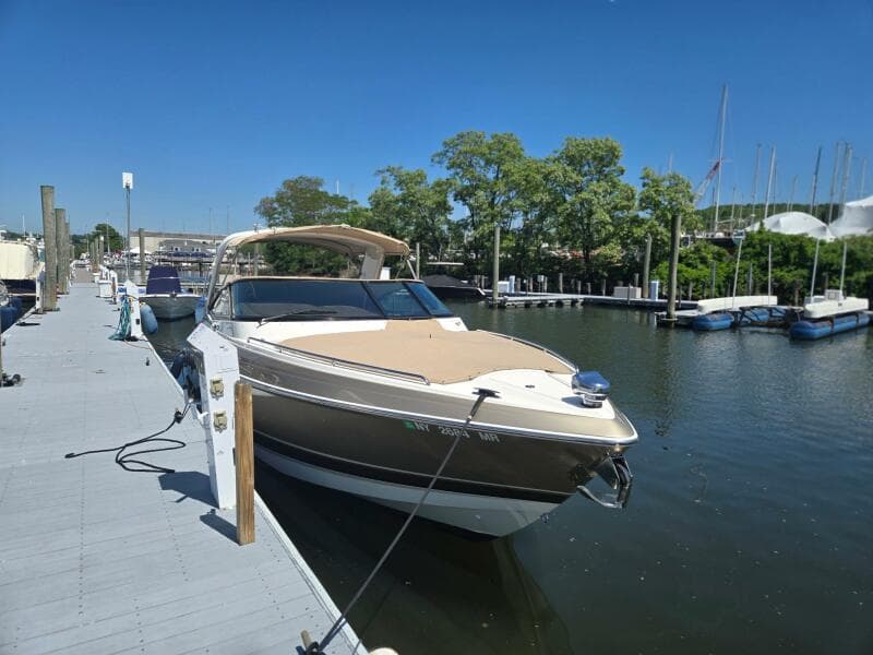 2015 Formula 330 Crossover Bowrider docked at marina under clear blue sky.