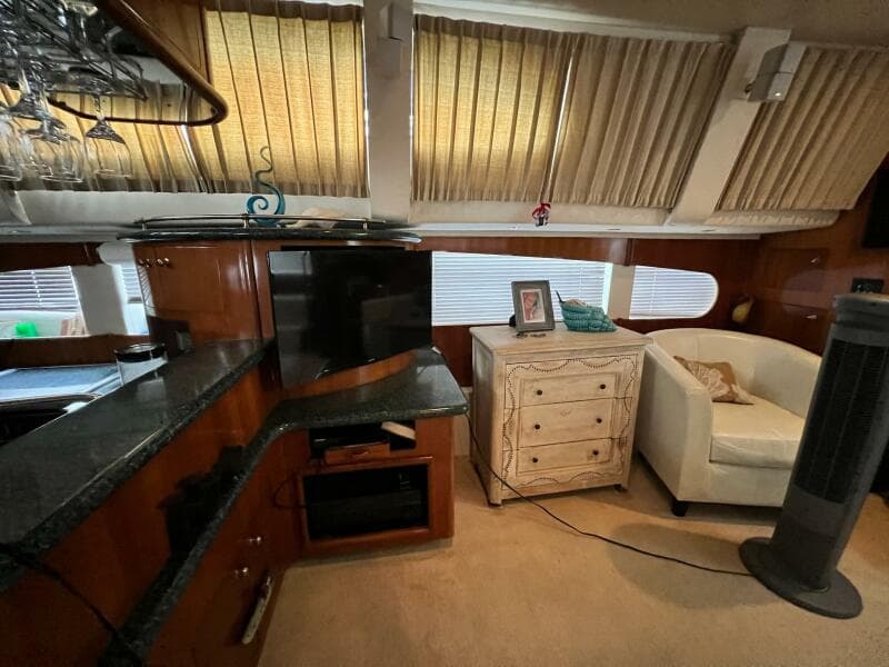 Interior of 2000 Carver 506 Motor Yacht with TV, cabinet, and seating area.