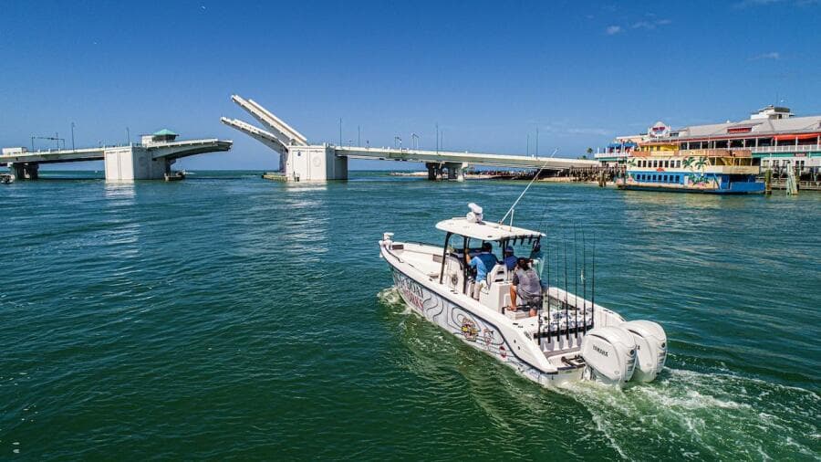 2023 CG Boat Works 35 M-Series cruising near an open drawbridge on a sunny day.