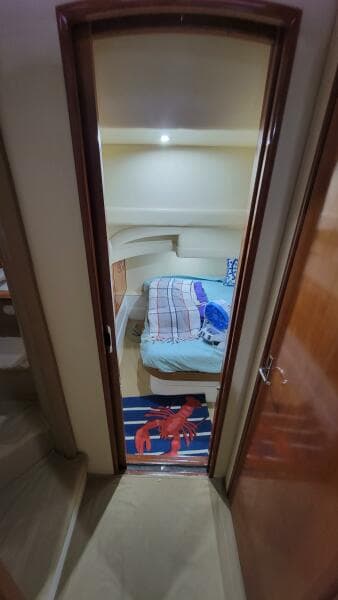 Interior cabin of a 2004 Carver 360 Sport Sedan with cozy bedding and nautical decor.