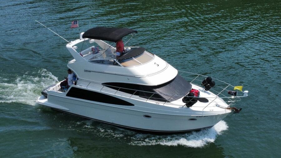 2004 Carver 360 Sport Sedan cruising on water, featuring sleek design and spacious deck.