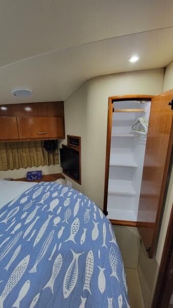 Interior of 2004 Carver 360 Sport Sedan with bed, closet, and wooden cabinetry.
