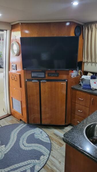 Interior of 2004 Carver 360 Sport Sedan with TV, fridge, and wooden cabinetry.
