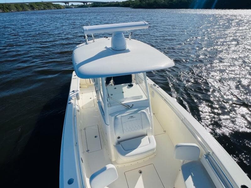 2021 Cobia 301 Center Console boat on a sunny day, cruising on open water.