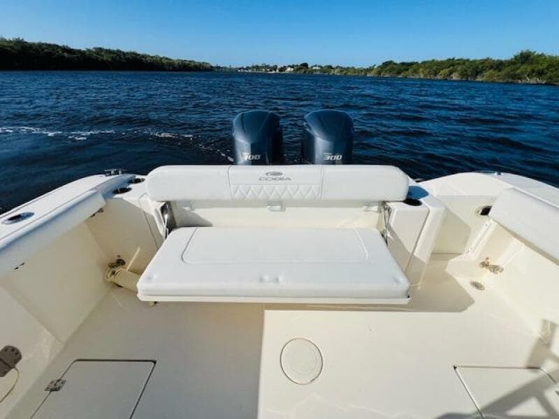 2021 Cobia 301 Center Console boat with dual engines on a calm waterway.