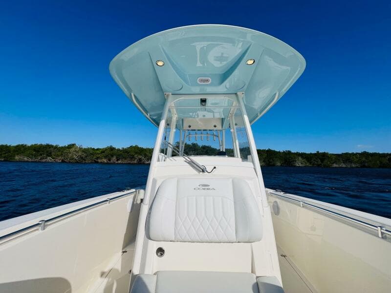 2021 Cobia 301 Center Console boat on open water under clear blue sky.